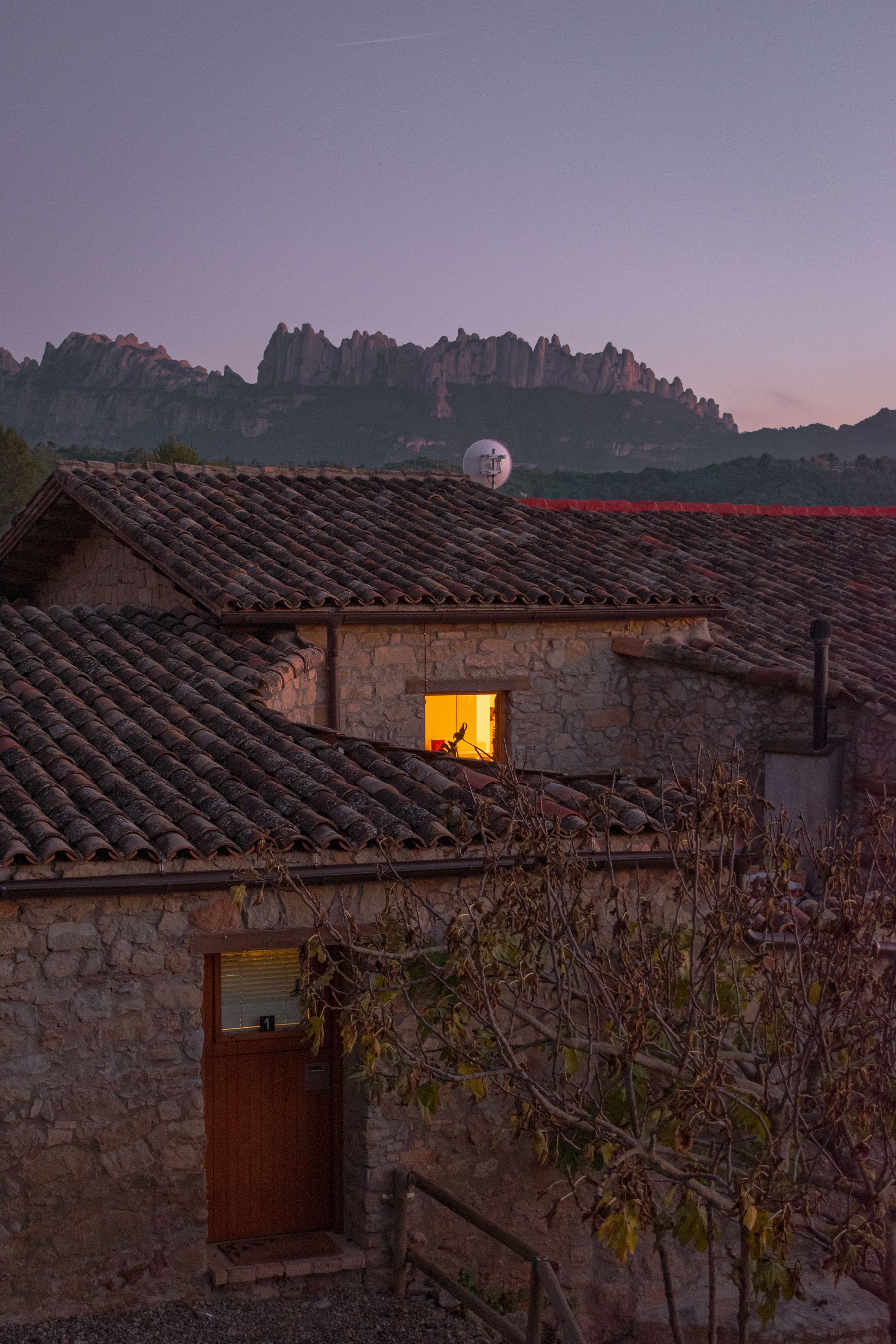 Casa rural tradicional de piedra al anochecer en un paisaje español